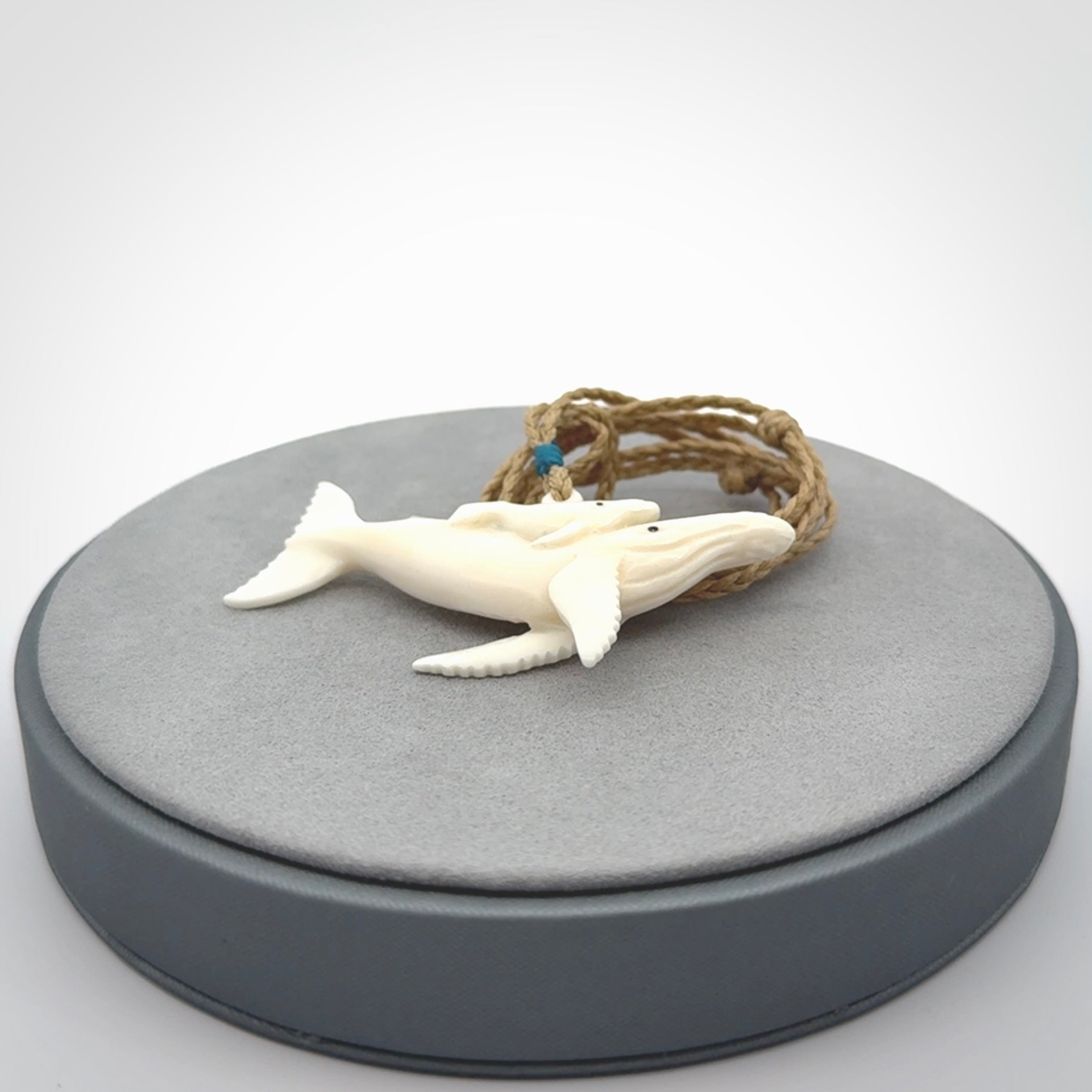 Hand carved bone whale and whale calf pendant