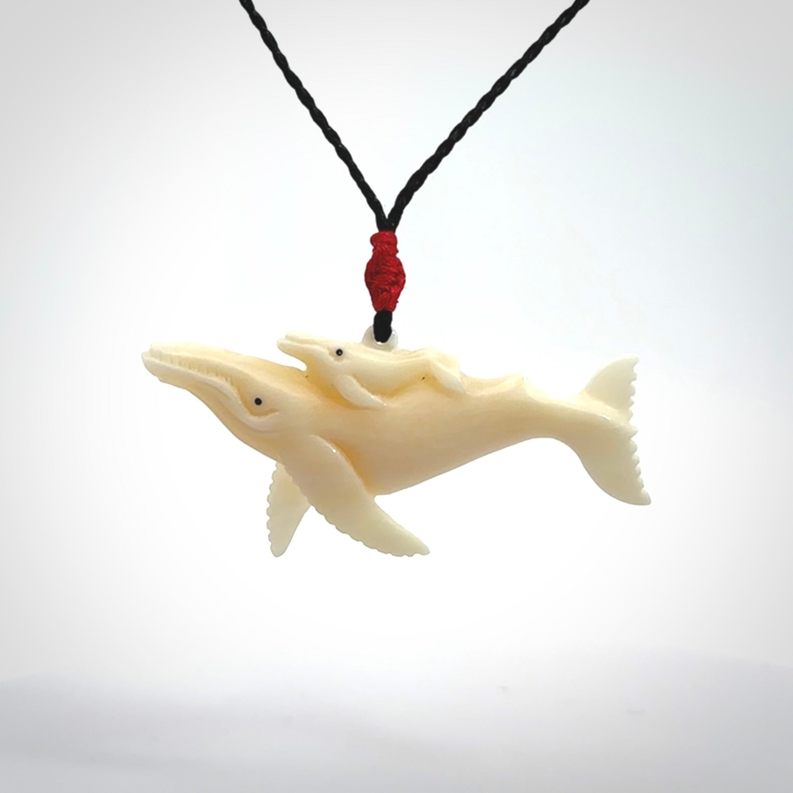 Hand carved bone whale and whale calf pendant