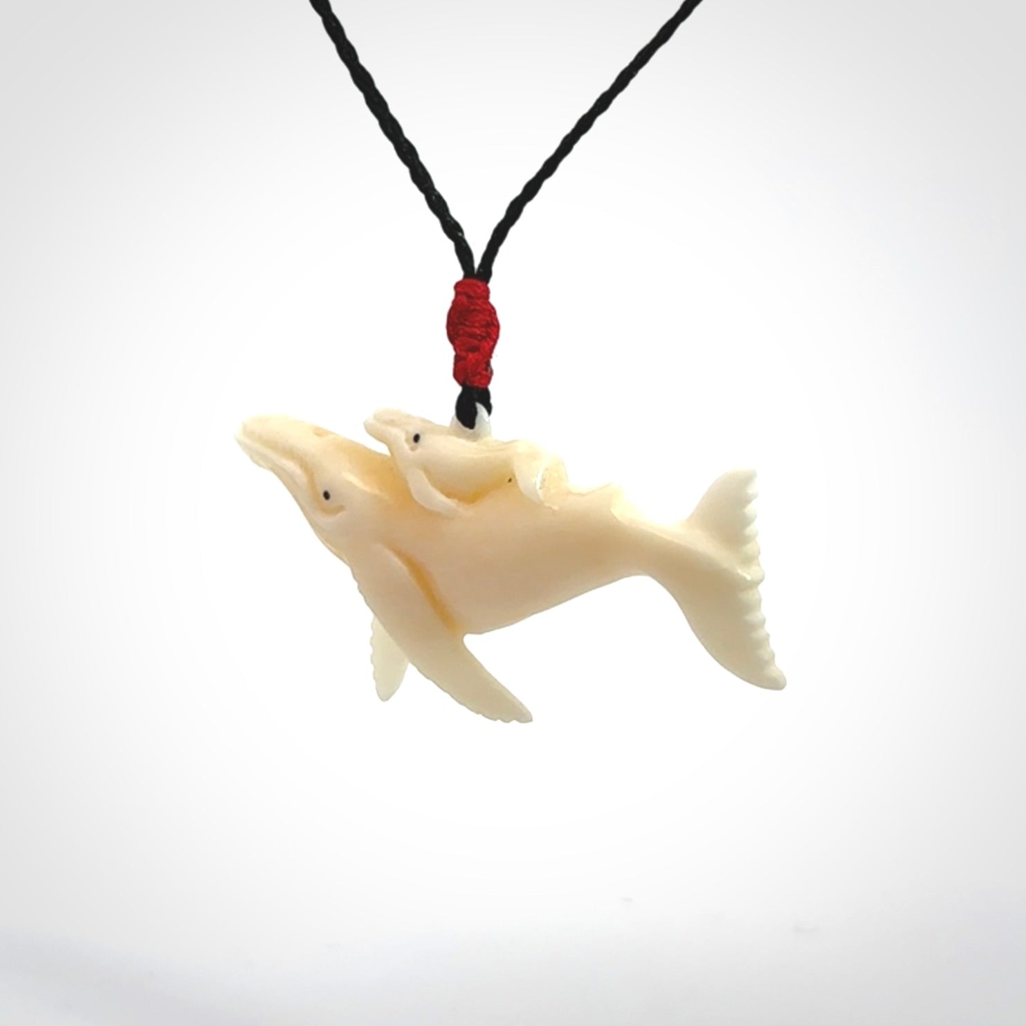 Hand carved bone whale and whale calf pendant