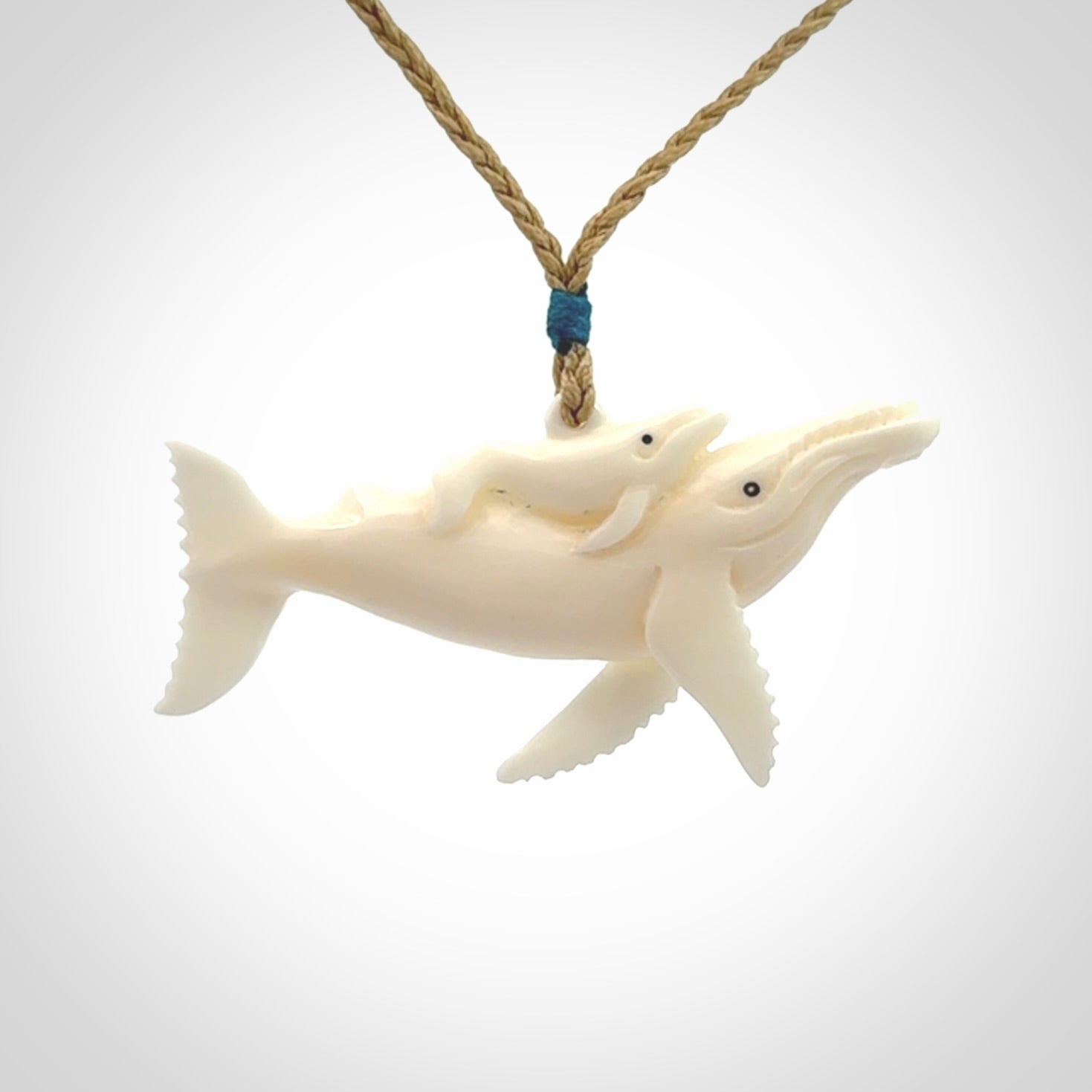 Hand carved bone whale and whale calf pendant