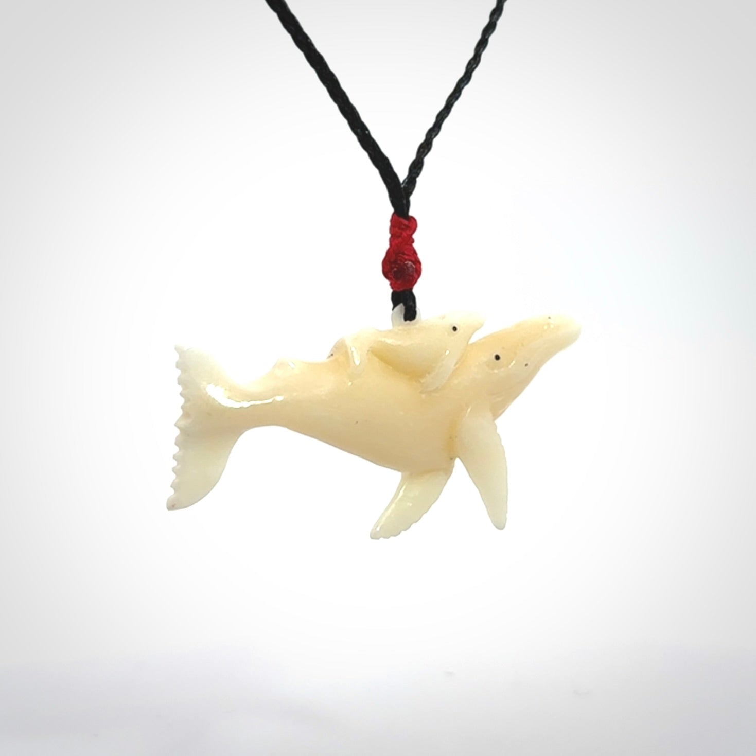 Hand carved bone whale and whale calf pendant
