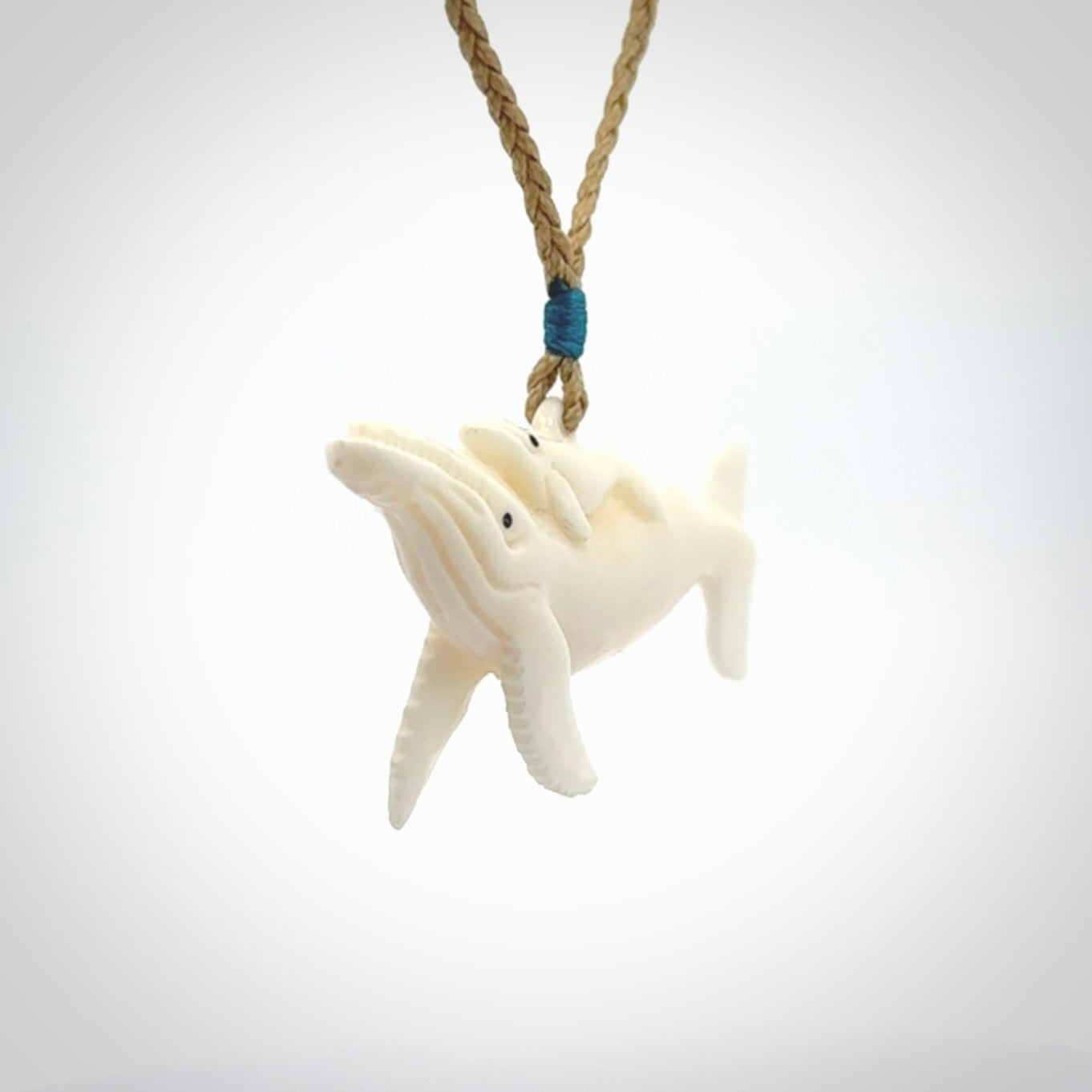 Hand carved bone whale and whale calf pendant