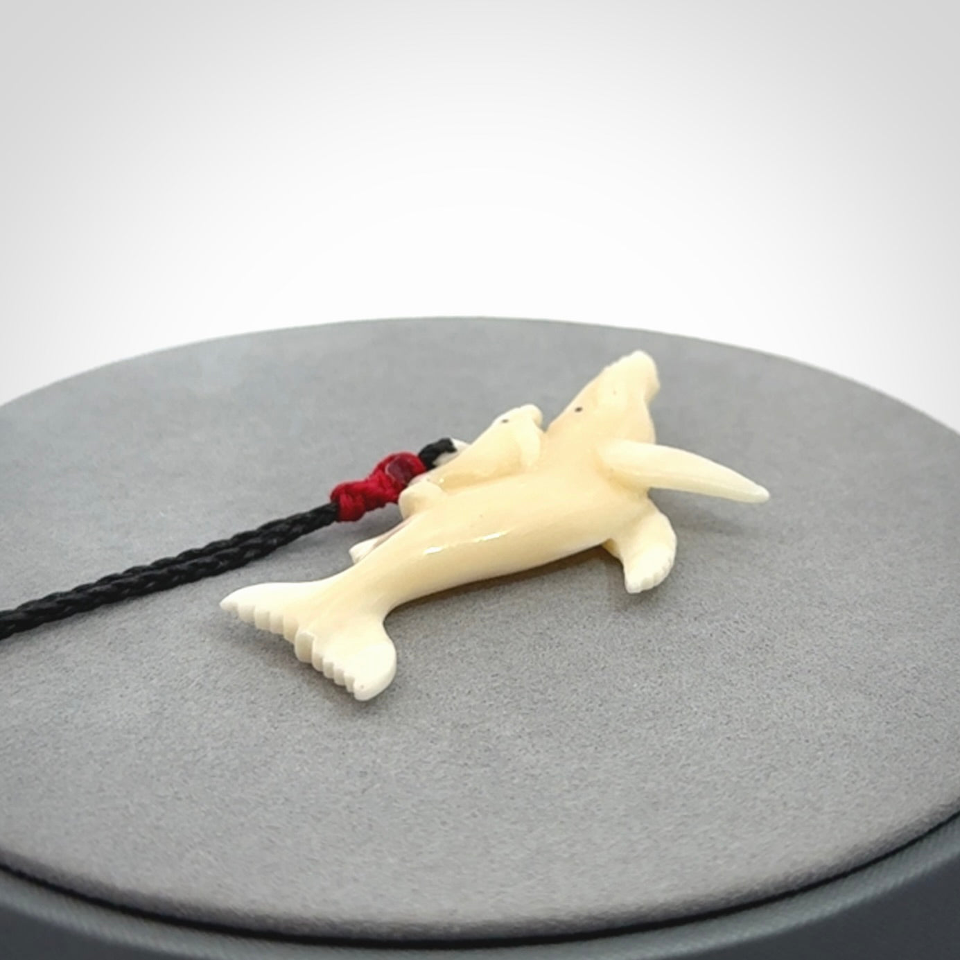 Hand carved bone whale and whale calf pendant