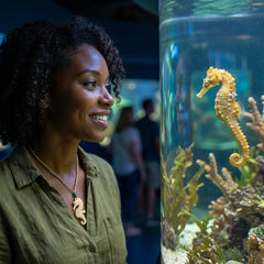 A woman wearing a mammoth tusk seahorse pendant