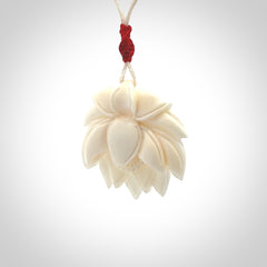 This is a hand carved lotus flower pendant. It is made from bone. This is a medium sized necklace and is a very unique pendant and is a wonderful necklace to wear. Hand carved bone lotus flower pendant with adjustable cord.