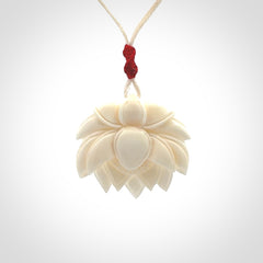 This is a hand carved lotus flower pendant. It is made from bone. This is a medium sized necklace and is a very unique pendant and is a wonderful necklace to wear. Hand carved bone lotus flower pendant with adjustable cord.
