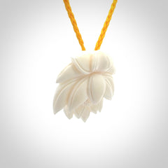 This is a hand carved lotus flower pendant. It is made from bone. This is a medium sized necklace and is a very unique pendant and is a wonderful necklace to wear. Hand carved bone lotus flower pendant with adjustable cord.