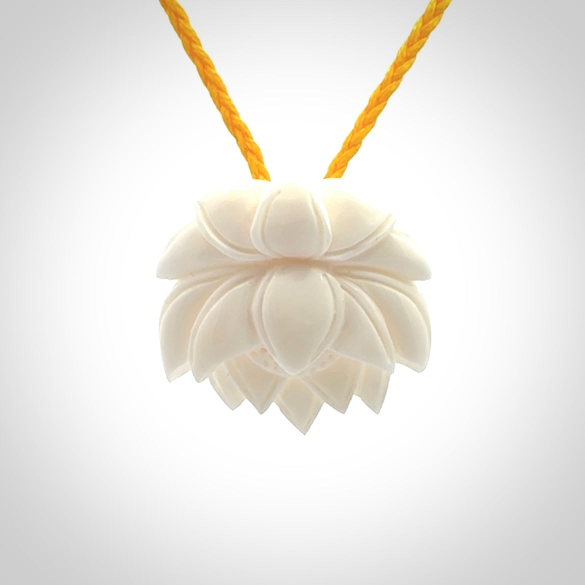 This is a hand carved lotus flower pendant. It is made from bone. This is a medium sized necklace and is a very unique pendant and is a wonderful necklace to wear. Hand carved bone lotus flower pendant with adjustable cord.