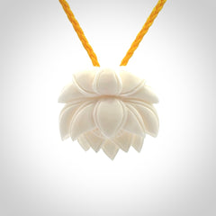 This is a hand carved lotus flower pendant. It is made from bone. This is a medium sized necklace and is a very unique pendant and is a wonderful necklace to wear. Hand carved bone lotus flower pendant with adjustable cord.
