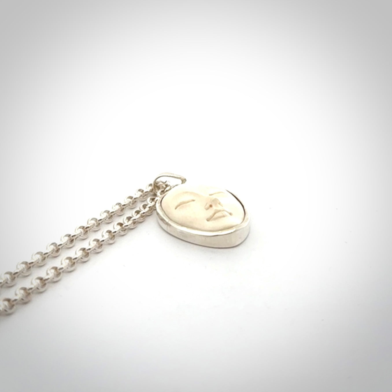 Hand made woolly mammoth tusk moon face necklace. Made by NZ Pacific and sale online only.