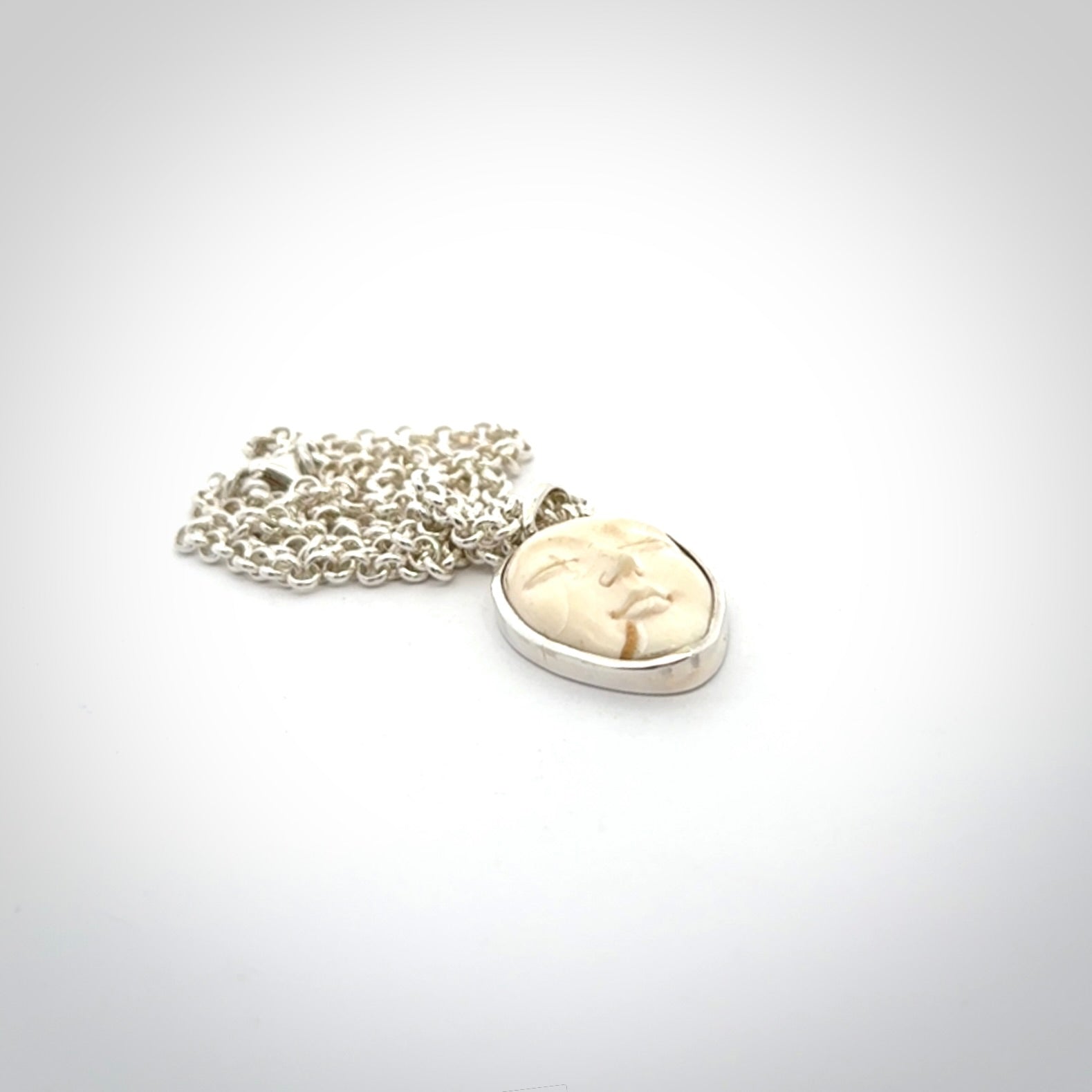 Hand made woolly mammoth tusk moon face necklace. Made by NZ Pacific and sale online only.