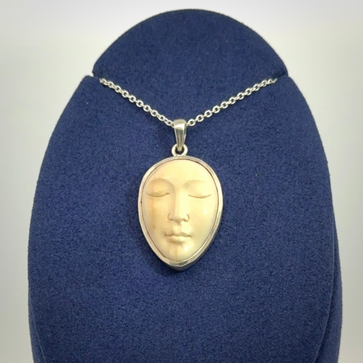 Hand made woolly mammoth tusk moon face necklace. Made by NZ Pacific and sale online only.