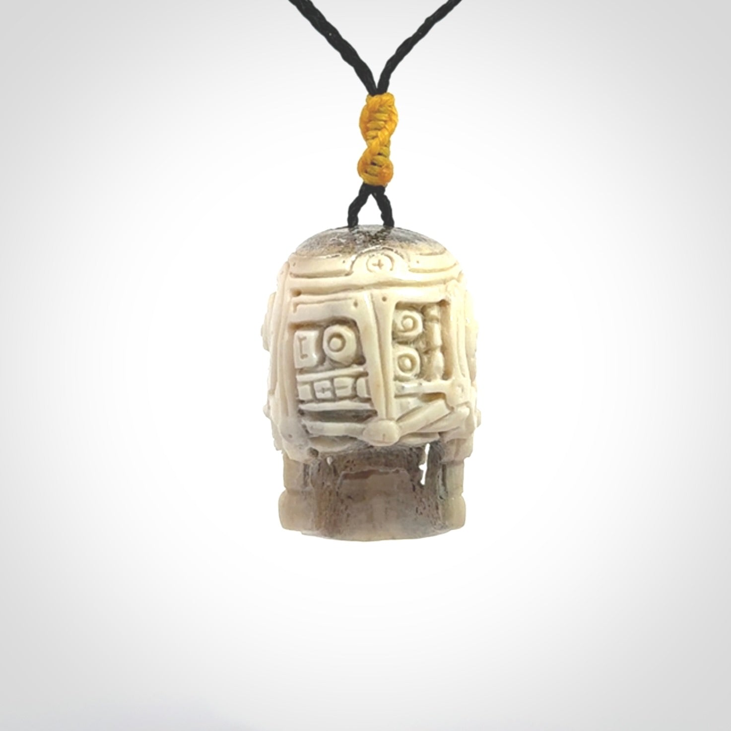 This picture shows a medium sized Deer Antler Bone robot skull pendant that we have hand carved. The cord is a black colour and has a small yellow binding just above the pendant.