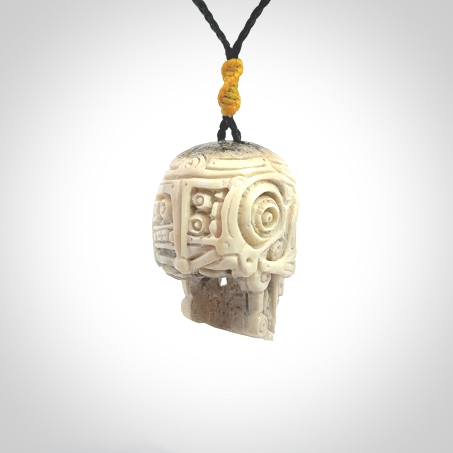 This picture shows a medium sized Deer Antler Bone robot skull pendant that we have hand carved. The cord is a black colour and has a small yellow binding just above the pendant.