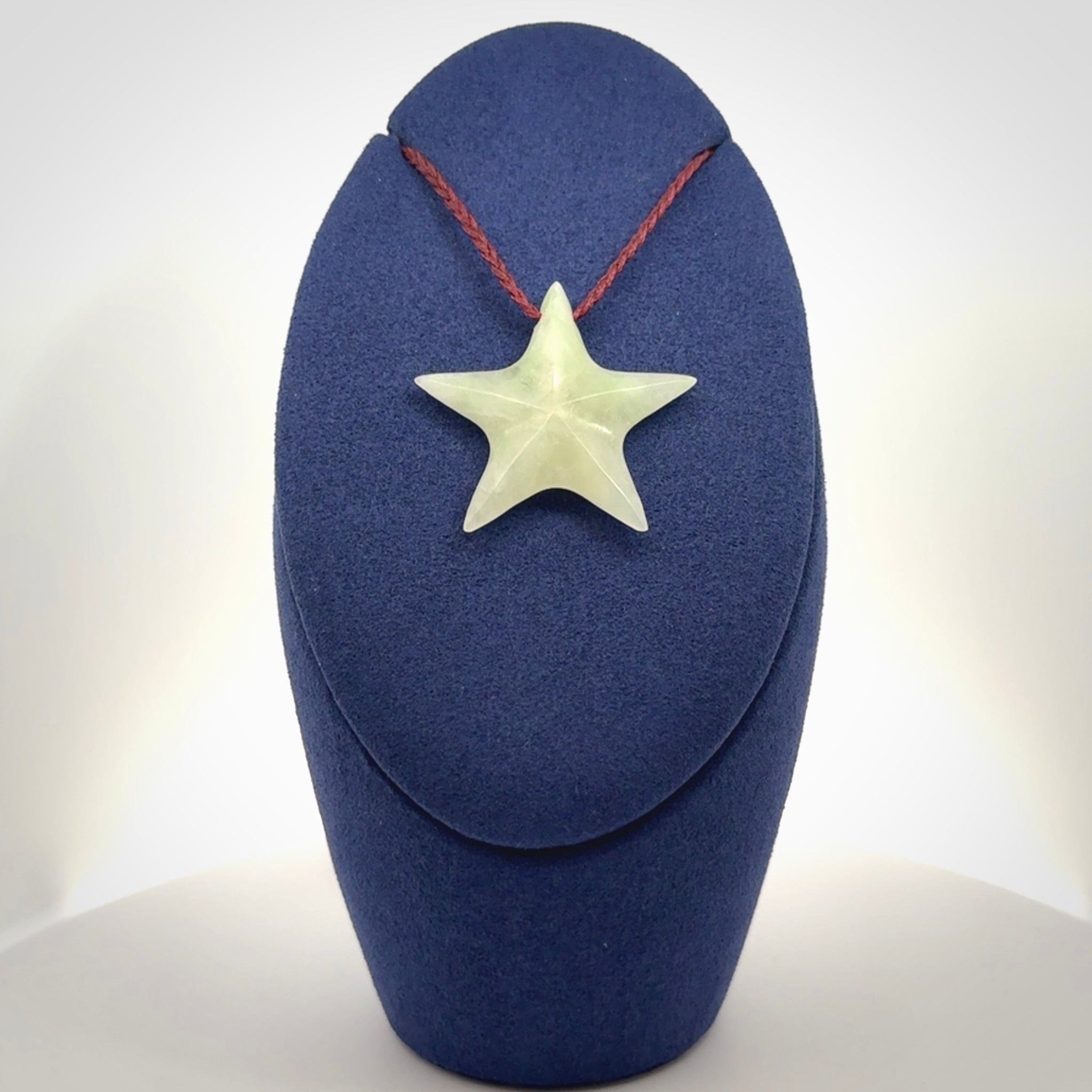 Small Jadeite star pendant. Star shaped necklace hand made from white Jadeite stone. Delivered on an adjustable plum coloured cord and packaged in a woven kete pouch.