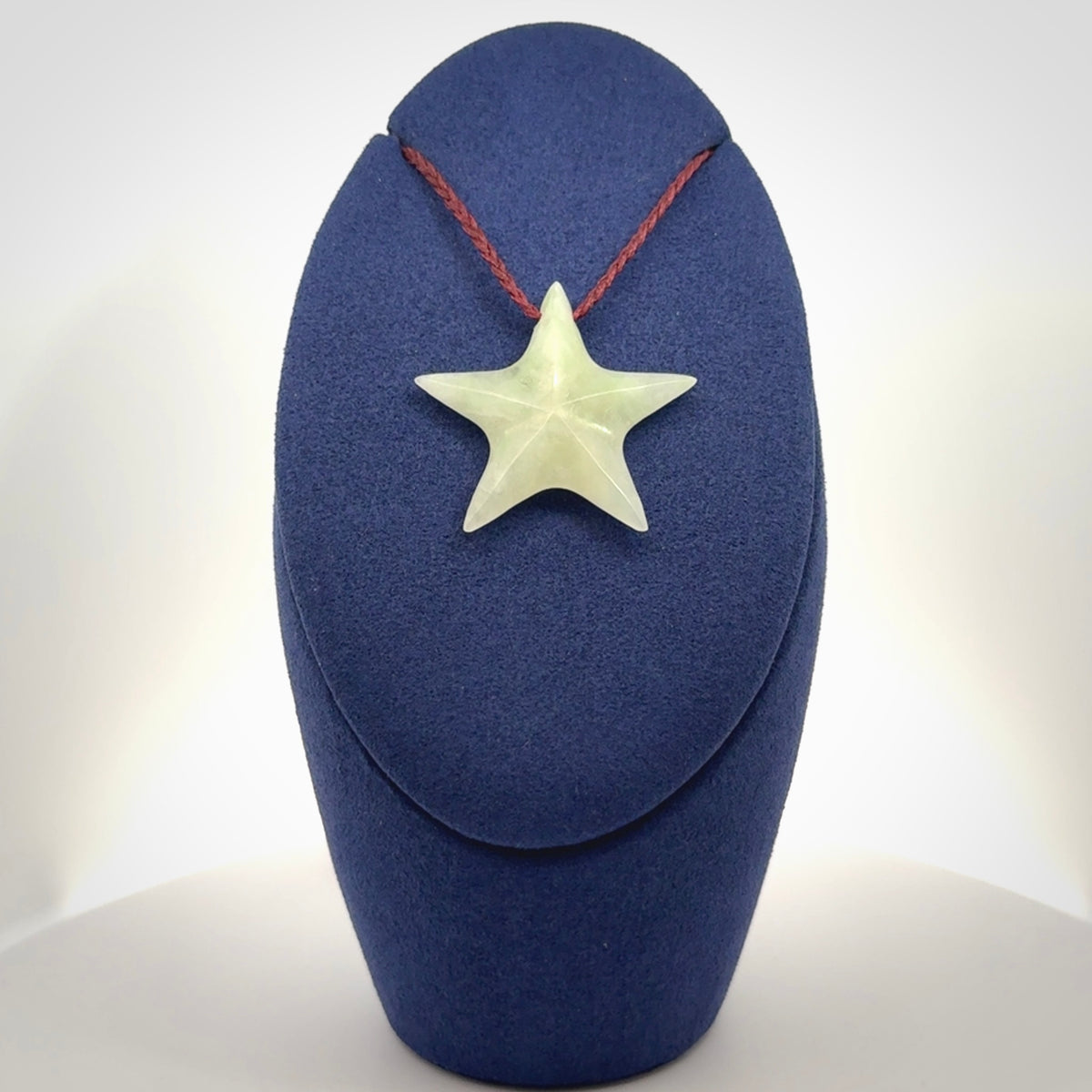 Small Jadeite star pendant. Star shaped necklace hand made from white Jadeite stone. Delivered on an adjustable plum coloured cord and packaged in a woven kete pouch.