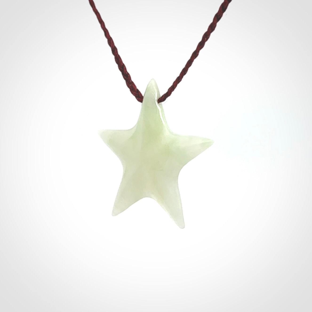 Small Jadeite star pendant. Star shaped necklace hand made from white Jadeite stone. Delivered on an adjustable plum coloured cord and packaged in a woven kete pouch.