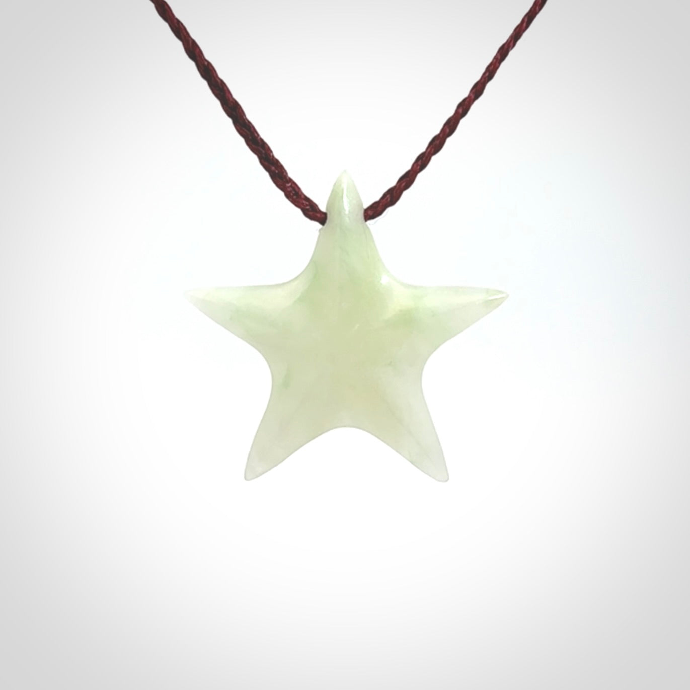Small Jadeite star pendant. Star shaped necklace hand made from white Jadeite stone. Delivered on an adjustable plum coloured cord and packaged in a woven kete pouch.