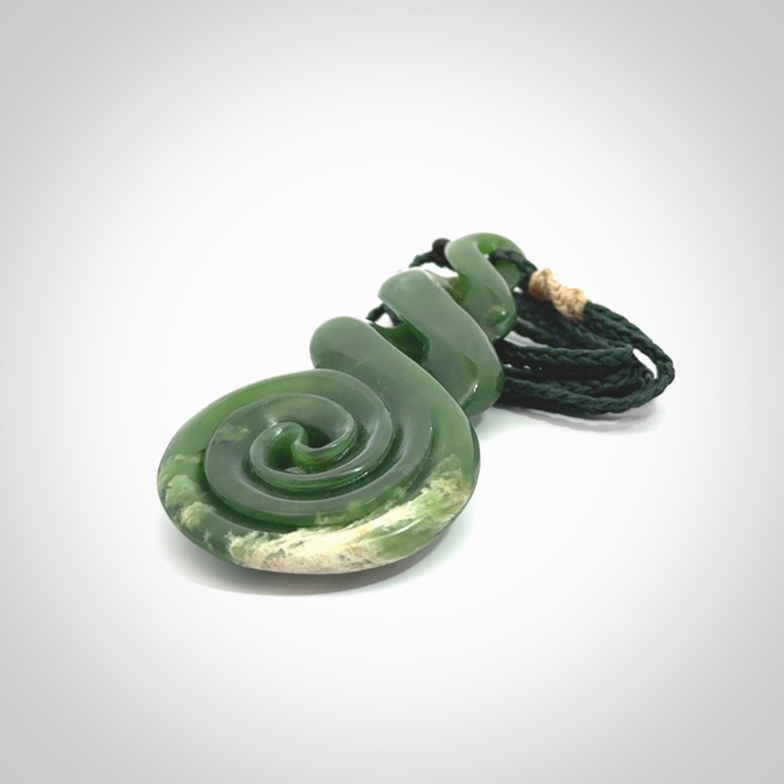 Ross Crump triple twist with koru pendant. Hand carved from rare New Zealand jade this is a beautiful pounamu pendant. The cord is length adjustable. It is a delicate and very beautiful greenstone pendant. For sale online by NZ Pacific.