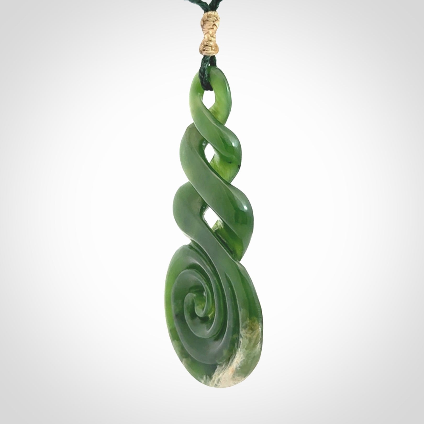 Ross Crump triple twist with koru pendant. Hand carved from rare New Zealand jade this is a beautiful pounamu pendant. The cord is length adjustable. It is a delicate and very beautiful greenstone pendant. For sale online by NZ Pacific.