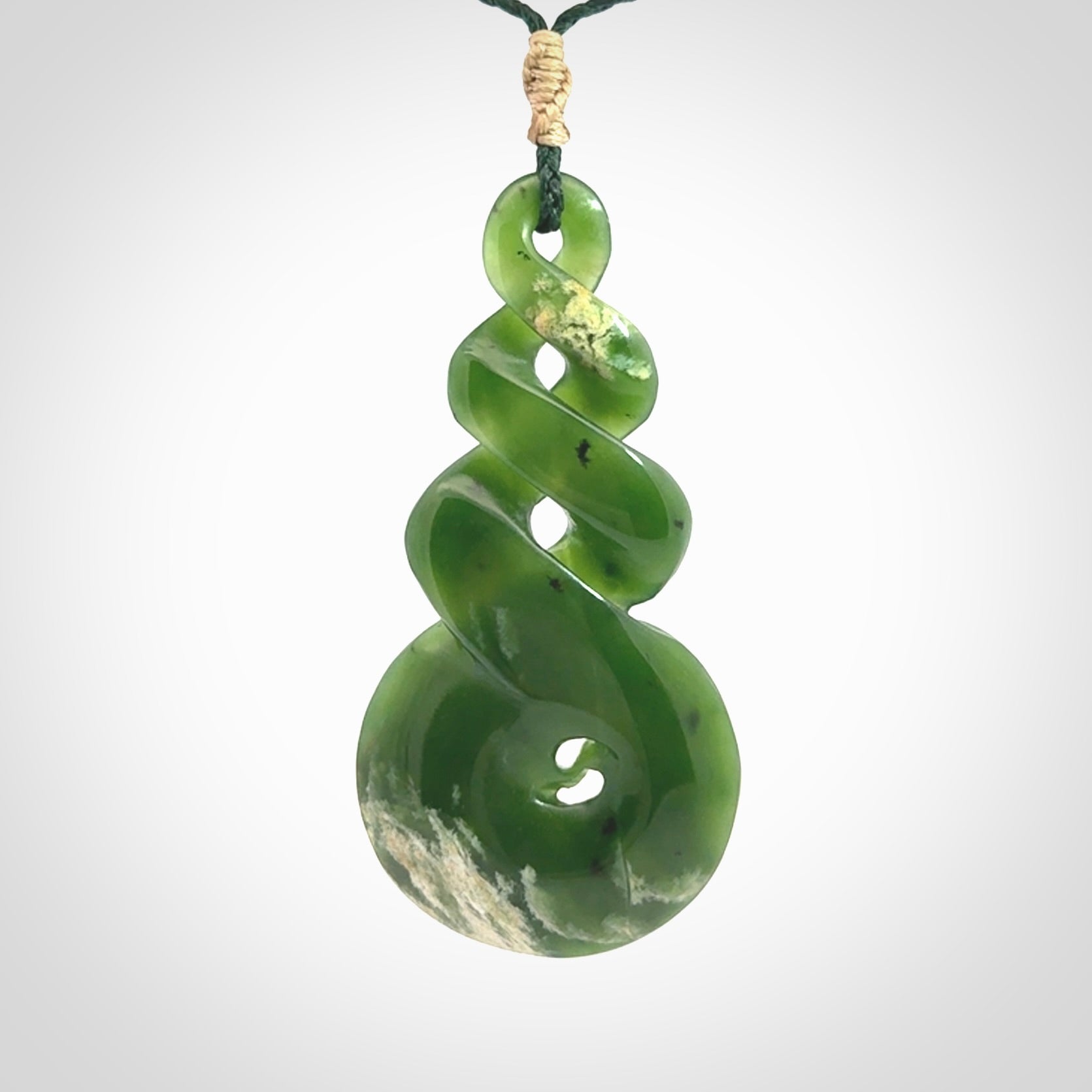 Ross Crump triple twist with koru pendant. Hand carved from rare New Zealand jade this is a beautiful pounamu pendant. The cord is length adjustable. It is a delicate and very beautiful greenstone pendant. For sale online by NZ Pacific.