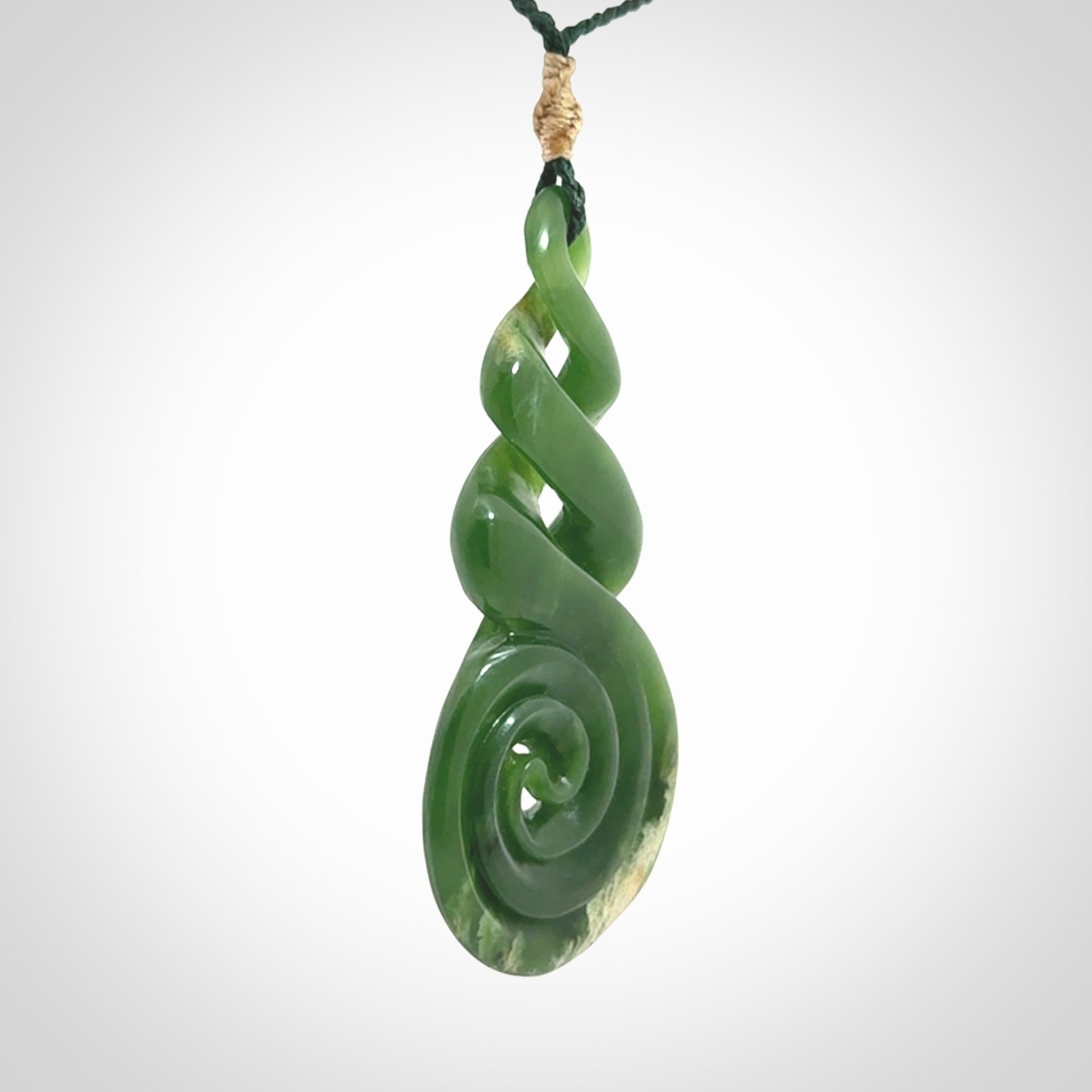 Ross Crump triple twist with koru pendant. Hand carved from rare New Zealand jade this is a beautiful pounamu pendant. The cord is length adjustable. It is a delicate and very beautiful greenstone pendant. For sale online by NZ Pacific.