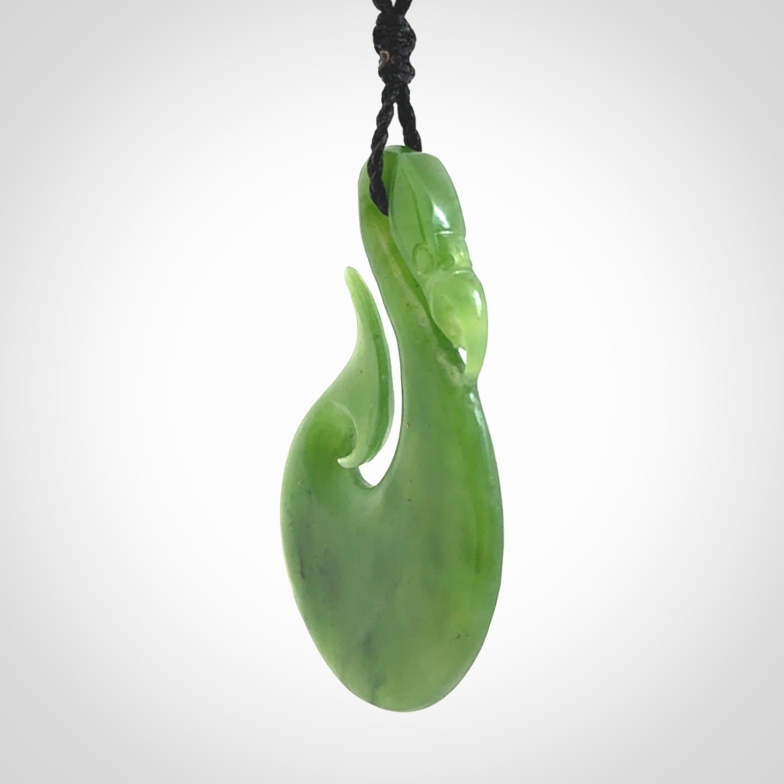 A New Zealand jade manaia necklace carved in lovely green New Zealand jade. The pendant is suspended from a plaited cord. The cord is length adjustable so you can position the pendant where it suits you best. One only Ross Crump Manaia with hook pendant.