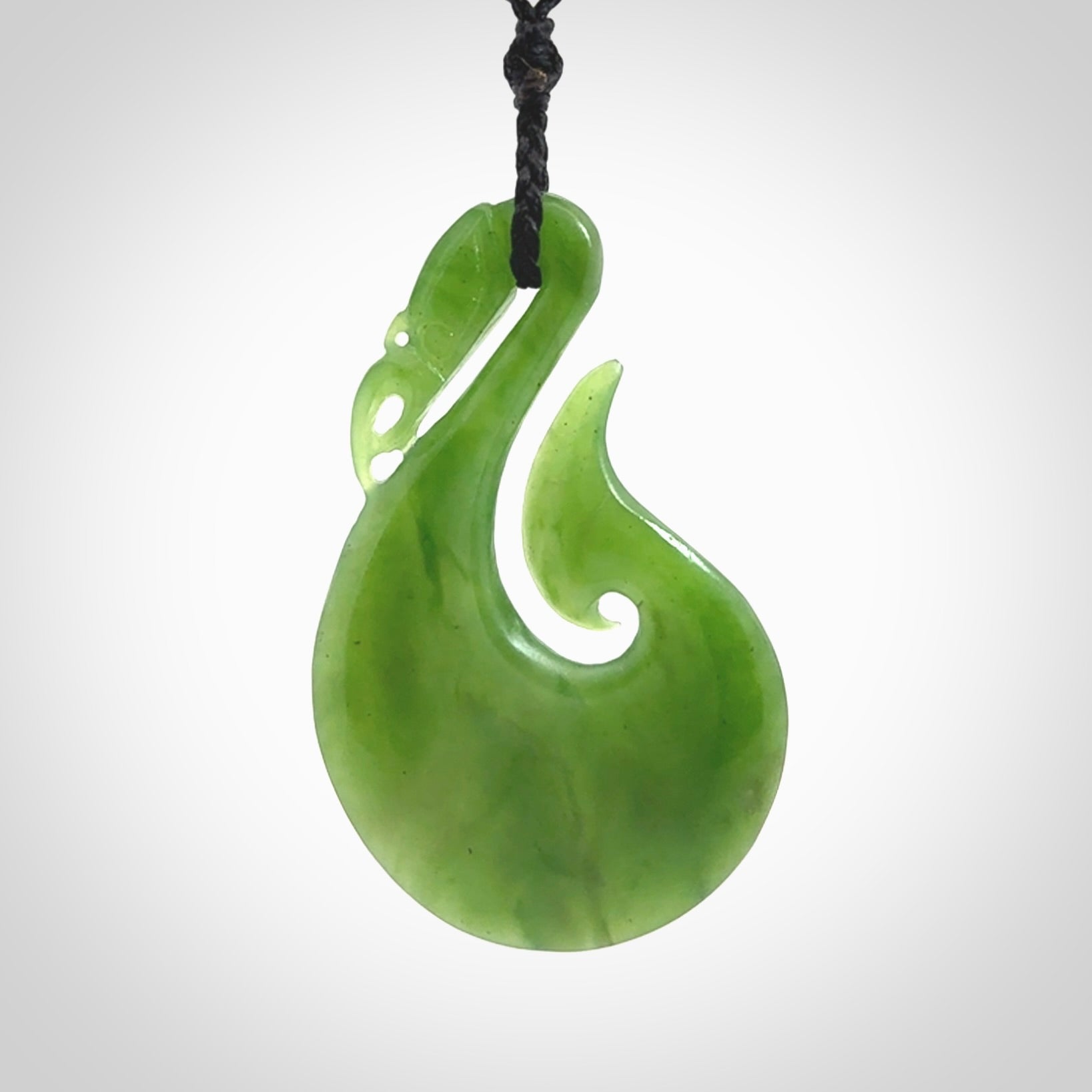 A New Zealand jade manaia necklace carved in lovely green New Zealand jade. The pendant is suspended from a plaited cord. The cord is length adjustable so you can position the pendant where it suits you best. One only Ross Crump Manaia with hook pendant.