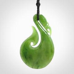 A New Zealand jade manaia necklace carved in lovely green New Zealand jade. The pendant is suspended from a plaited cord. The cord is length adjustable so you can position the pendant where it suits you best. One only Ross Crump Manaia with hook pendant.