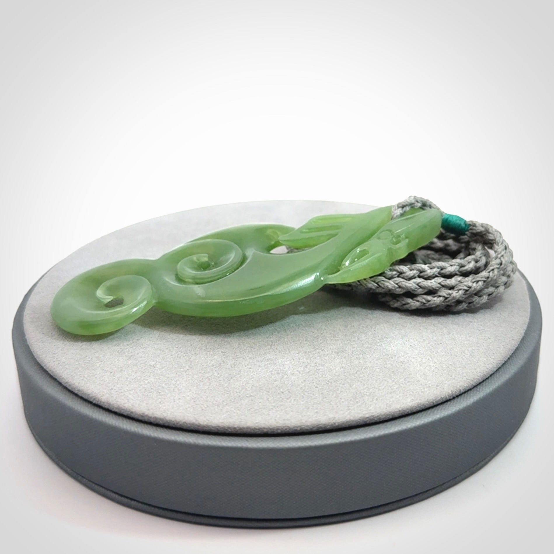 This pendant is a beautiful large New Zealand Inanga jade manaia pendant with koru. It has the head of a bird and the tail of a fish and also two koru carved into the body. It is carved by Ross Crump here in New Zealand. Provided with an adjustable Grey cord.