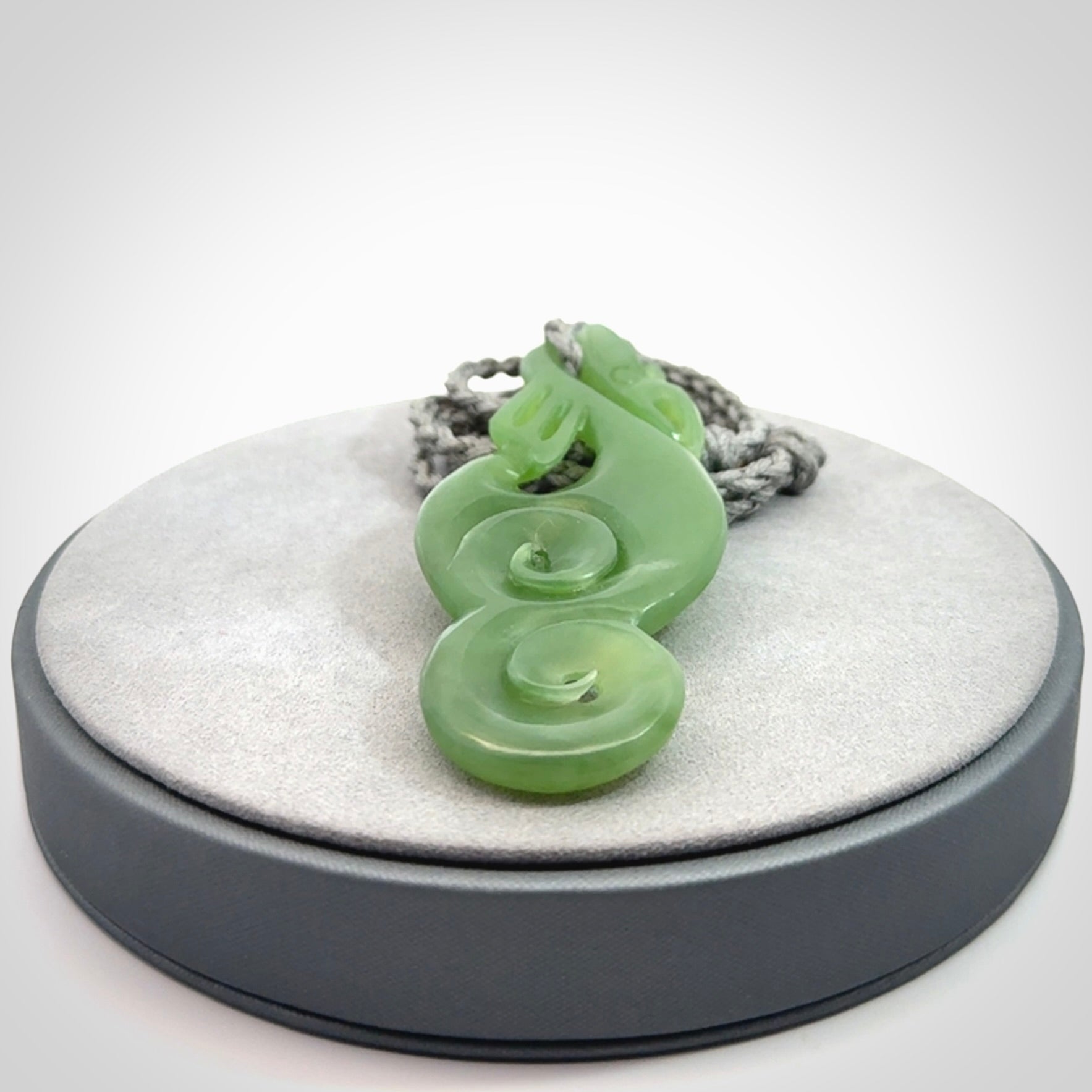 This pendant is a beautiful large New Zealand Inanga jade manaia pendant with koru. It has the head of a bird and the tail of a fish and also two koru carved into the body. It is carved by Ross Crump here in New Zealand. Provided with an adjustable Grey cord.