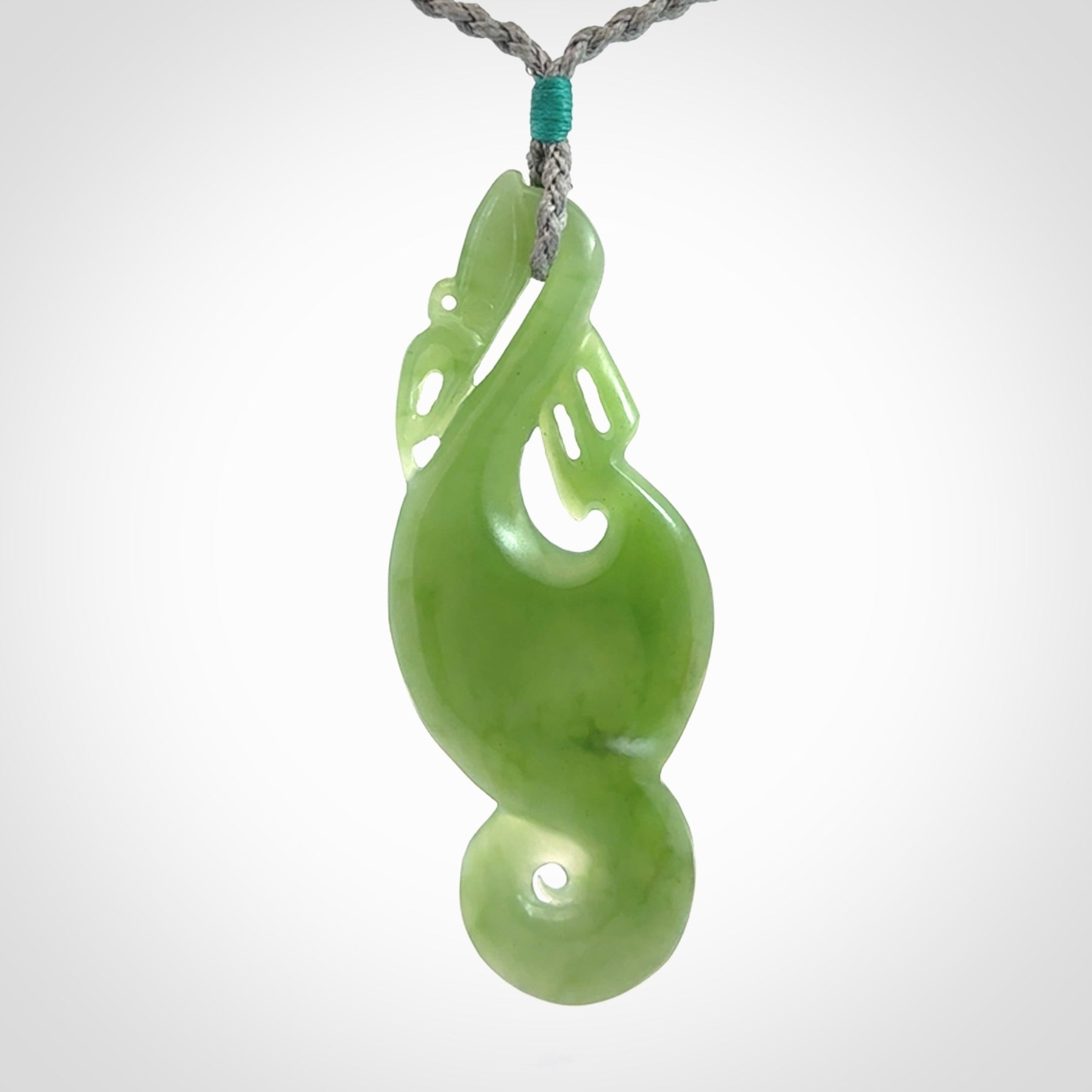 This pendant is a beautiful large New Zealand Inanga jade manaia pendant with koru. It has the head of a bird and the tail of a fish and also two koru carved into the body. It is carved by Ross Crump here in New Zealand. Provided with an adjustable Grey cord.