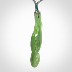 This pendant is a beautiful large New Zealand Inanga jade manaia pendant with koru. It has the head of a bird and the tail of a fish and also two koru carved into the body. It is carved by Ross Crump here in New Zealand. Provided with an adjustable Grey cord.