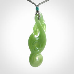 This pendant is a beautiful large New Zealand Inanga jade manaia pendant with koru. It has the head of a bird and the tail of a fish and also two koru carved into the body. It is carved by Ross Crump here in New Zealand. Provided with an adjustable Grey cord.