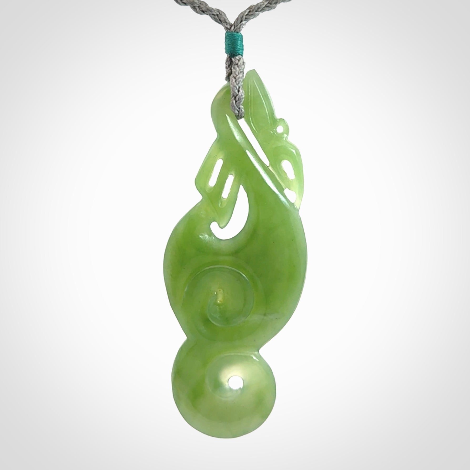 This pendant is a beautiful large New Zealand Inanga jade manaia pendant with koru. It has the head of a bird and the tail of a fish and also two koru carved into the body. It is carved by Ross Crump here in New Zealand. Provided with an adjustable Grey cord.