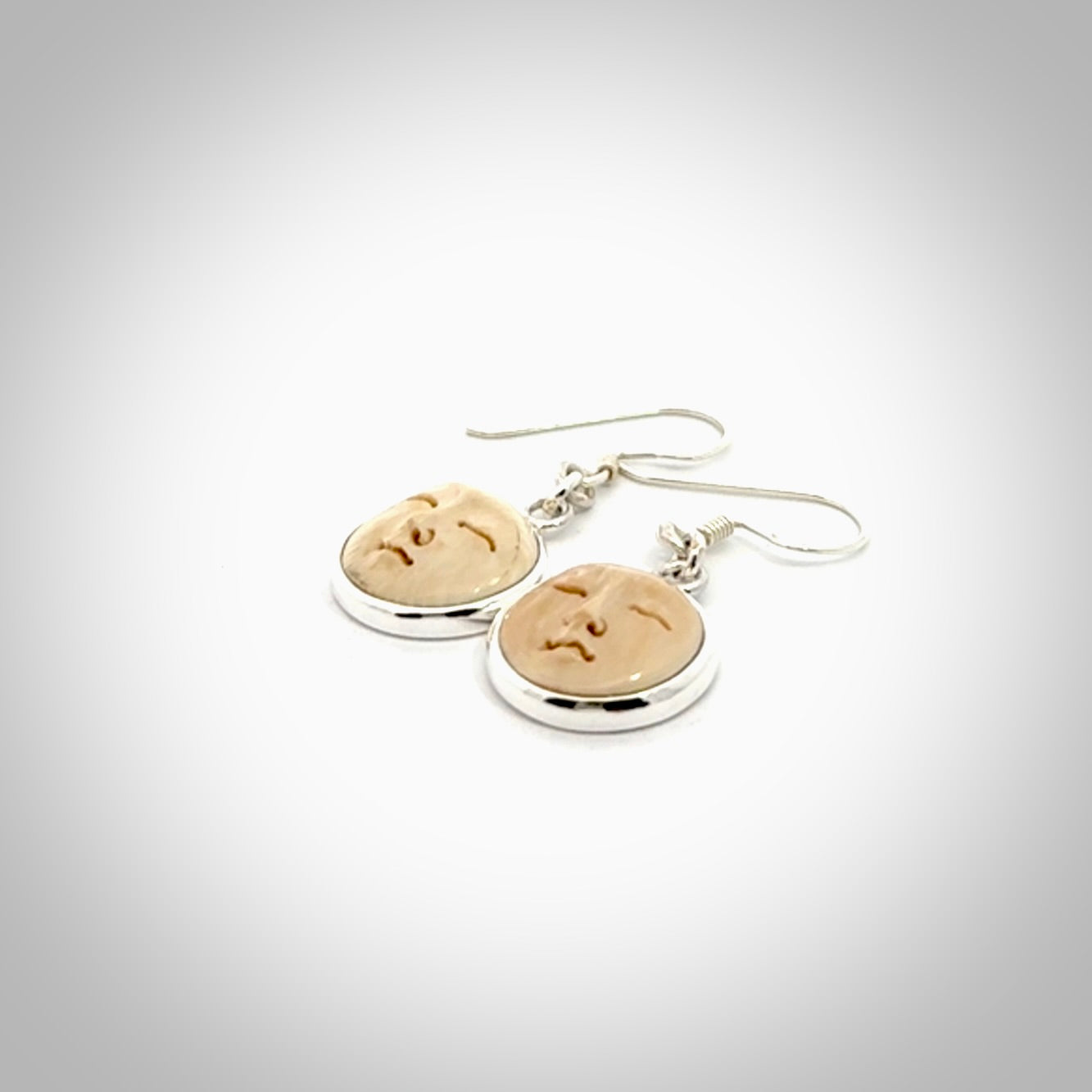Hand made woolly mammoth tusk moon face earrings. Made by NZ Pacific and sale online only.
