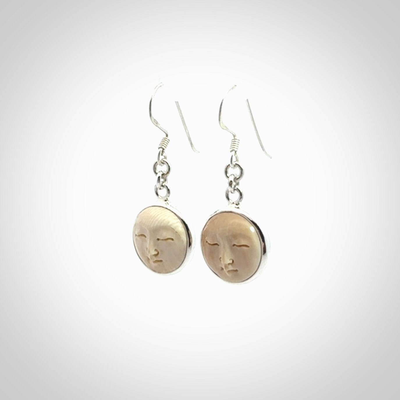 Hand made woolly mammoth tusk moon face earrings. Made by NZ Pacific and sale online only.
