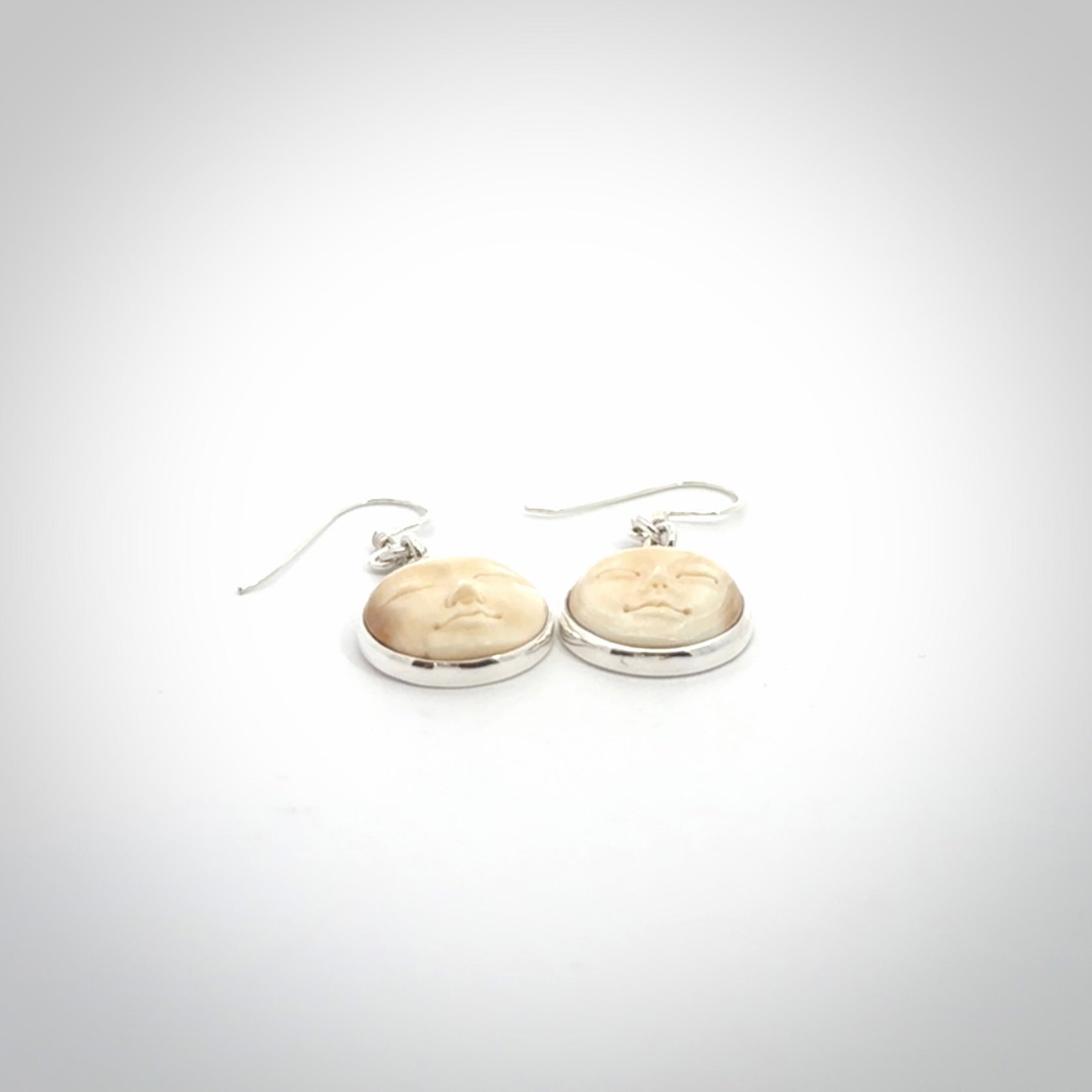 Hand made woolly mammoth tusk moon face earrings. Made by NZ Pacific and sale online only.