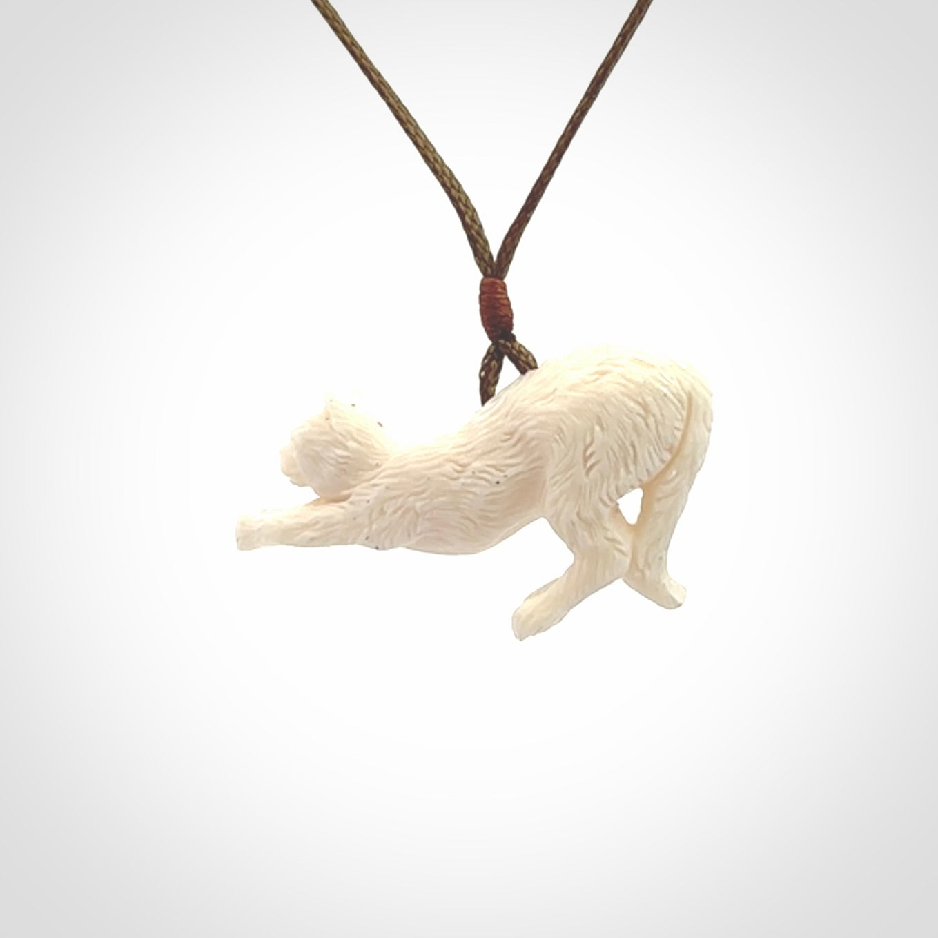 Hand carved bone cat stretching pendant