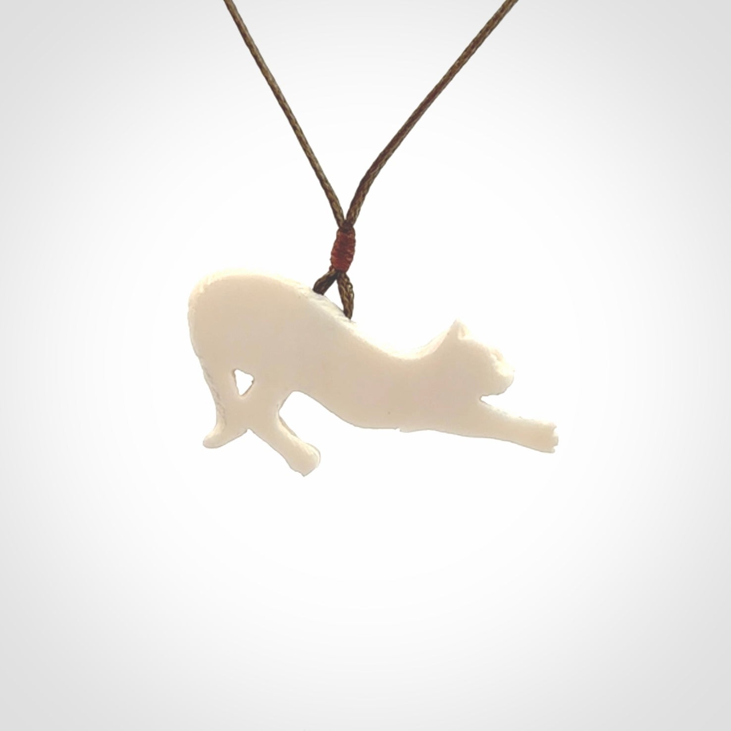 Hand carved bone cat stretching pendant