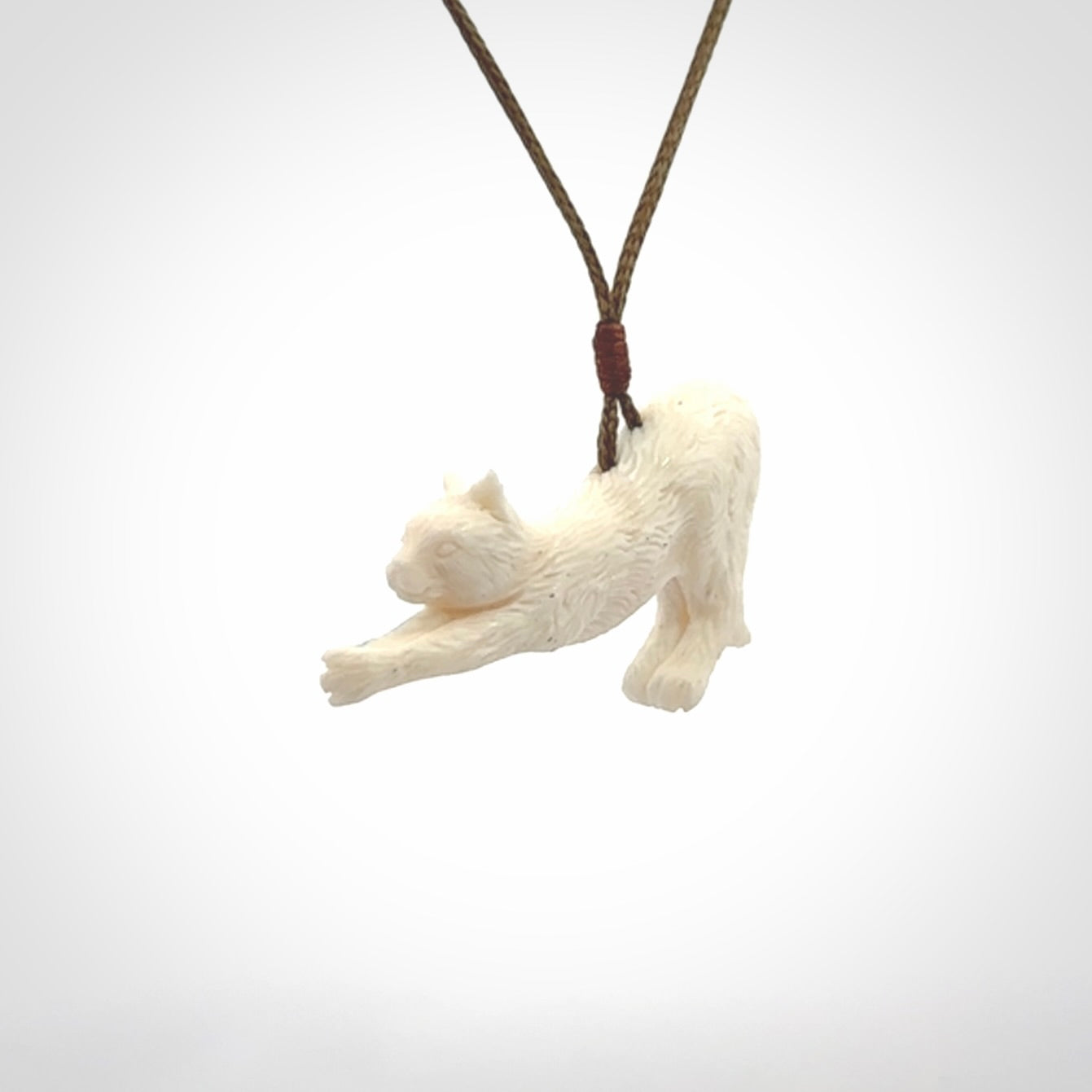 Hand carved bone cat stretching pendant