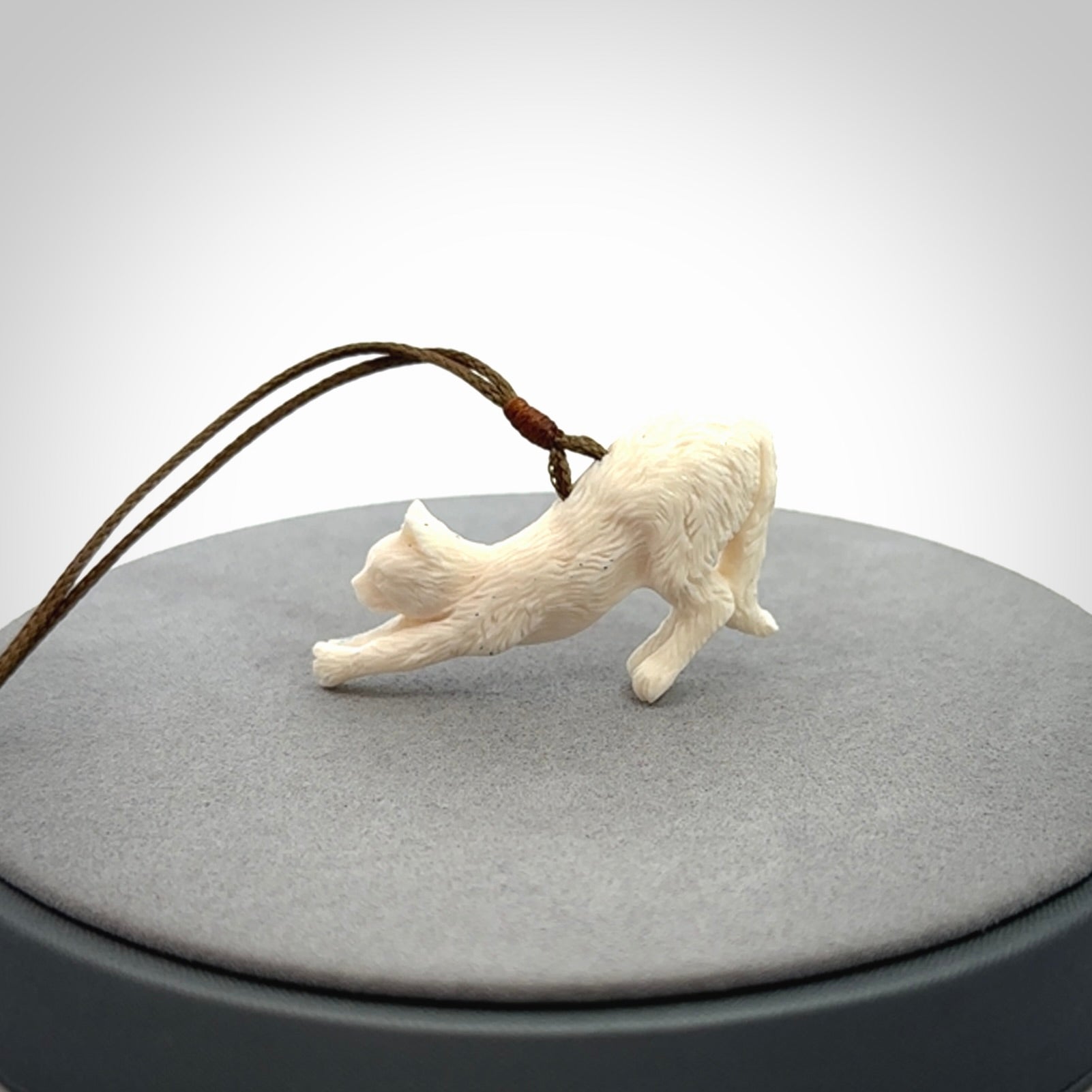 Hand carved bone cat stretching pendant