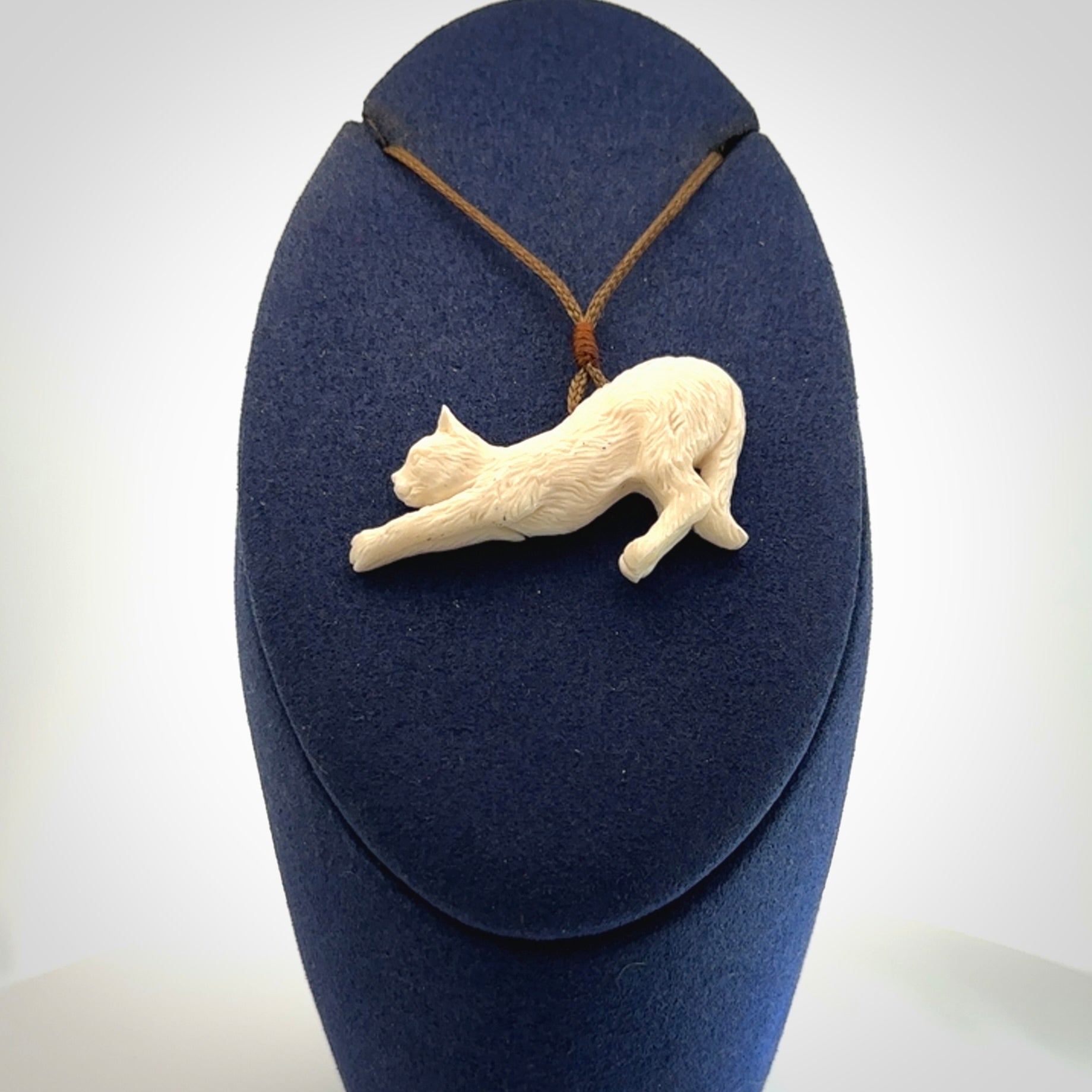 Hand carved bone cat stretching pendant