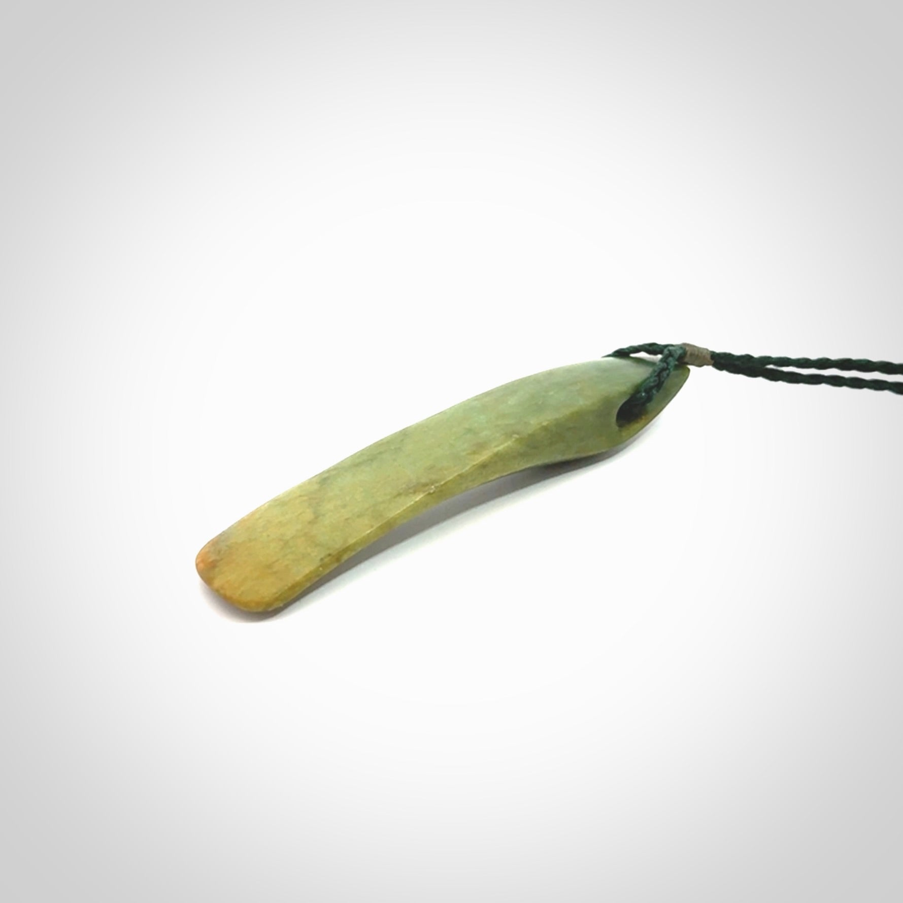 This is a lovely, large, New Zealand Flower Jade, pounamu drop pendant. Hand carved for us by Ric Moor. It is bound with an adjustable manuka green coloured cord which is length adjustable.