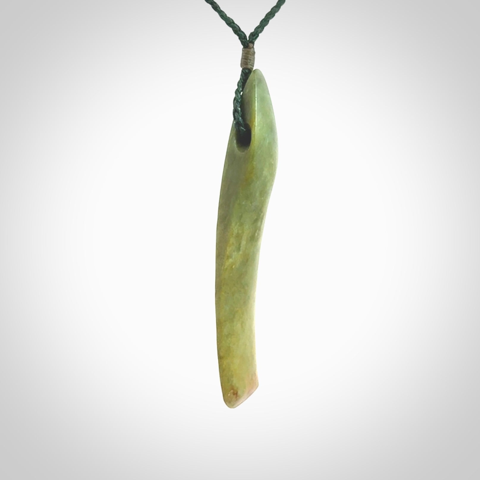 This is a lovely, large, New Zealand Flower Jade, pounamu drop pendant. Hand carved for us by Ric Moor. It is bound with an adjustable manuka green coloured cord which is length adjustable.