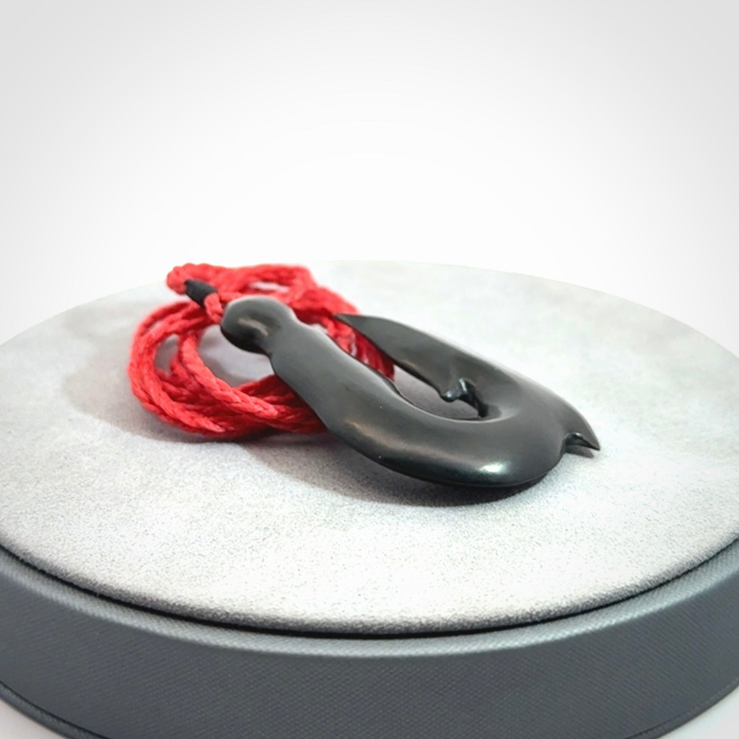 These pendants are hand carved, black jade hooks or matau pendants. They are beautifully finished in a polish and bound with adjustable necklace cords