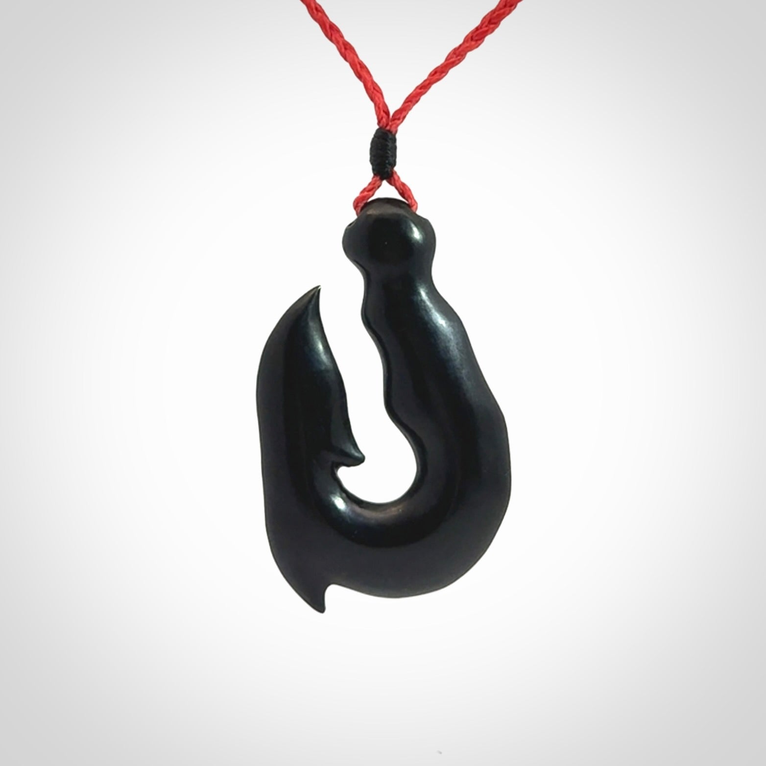 These pendants are hand carved, black jade hooks or matau pendants. They are beautifully finished in a polish and bound with adjustable necklace cords