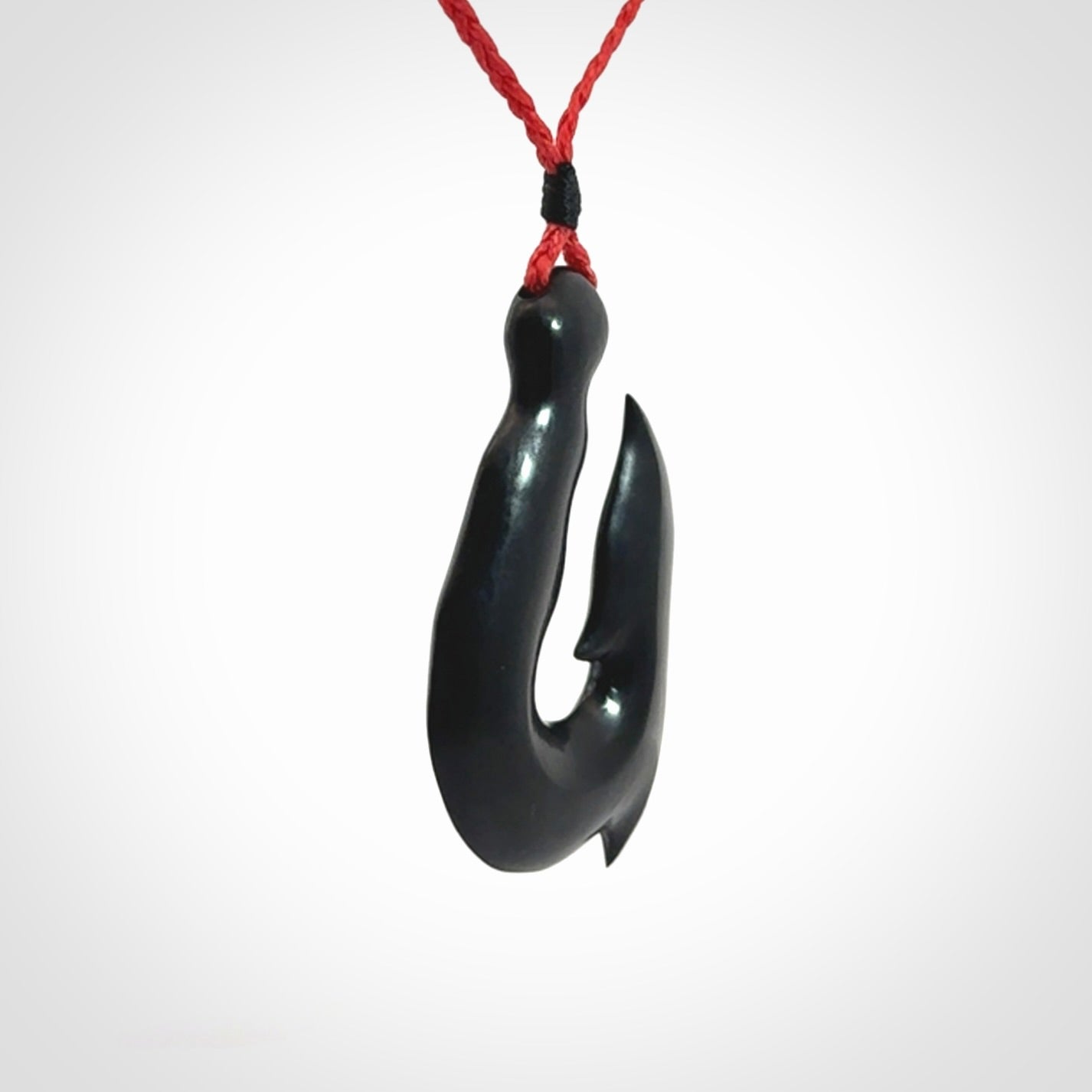 These pendants are hand carved, black jade hooks or matau pendants. They are beautifully finished in a polish and bound with adjustable necklace cords