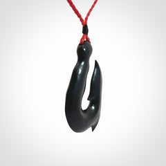 These pendants are hand carved, black jade hooks or matau pendants. They are beautifully finished in a polish and bound with adjustable necklace cords