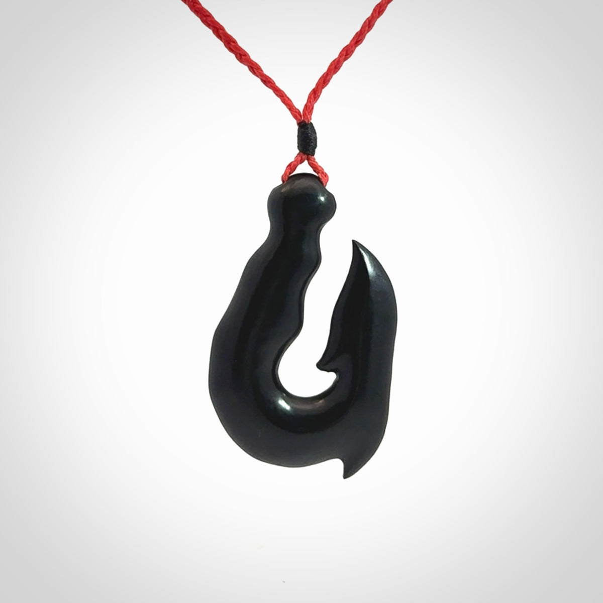 These pendants are hand carved, black jade hooks or matau pendants. They are beautifully finished in a polish and bound with adjustable necklace cords